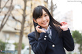 Student outdoors in uniform hands raised playing with her long hair