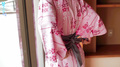 Hands behind her back loosening yukata