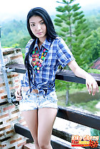 Standing on balcony wearing check shirt in denim shorts